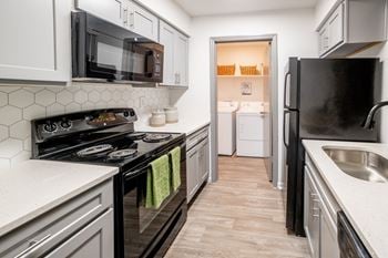 Kitchen with white cabinets and black appliances and a black refrigerator